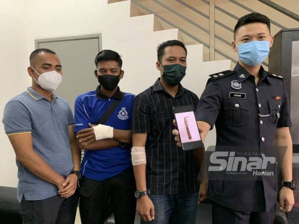 Shafien (kiri) bertanya khabar anggotanya yang tercedera dalam insiden berkenaan.