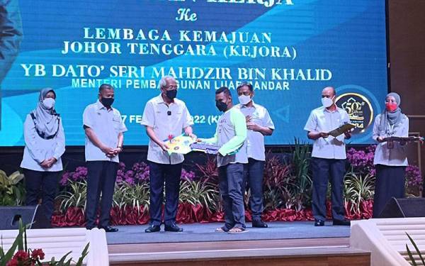 Mahdzir (tengah) menyampaikan sumbangan di bawah Inisiatif Rumah Kasih Keluarga Malaysia di Dewan Kejora Bandar Penawar di sini pada Khamis.