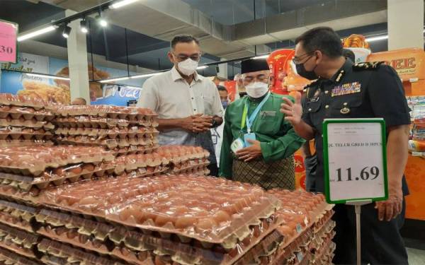 Rosol (kiri) melihat bekalan telur ketika Walkabout, kebersediaan barangan keperluan pengguna di kawasan luar bandar di Pasaraya BS Freshmart Bukit Goh di Lorong Padang Maju 2 di sini, pada Jumaat.
