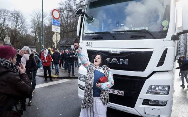 Seorang penunjuk perasaan sedang melaungkan slogan membantah vaksin mandatori di Belgium dengan meniru protes Freedom Convoy di Kanada. - AFP