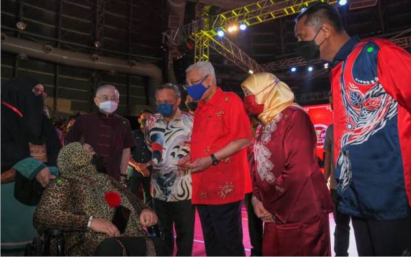 Ismail Sabri (tiga, kanan) menyampaikan Sumbangan Penggiat Seni dan Budaya Negeri Johor kepada Artis Rakaman Seni Suara, Aida Agil (duduk) pada Majlis Makan Malam Tahun Baharu Cina Kebersamaan Sesama Keluarga Malaysia di Stadium Tertutup Kompleks Sukan EduCity di Iskandar Puteri, pada malam Jumaat. - Foto Bernama