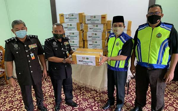 Nik Muhammad Zawawi (dua dari kanan) menyampaikan sumbangan produk hasilan haiwan di Penjara Pengkalan Chepa pada Sabtu.