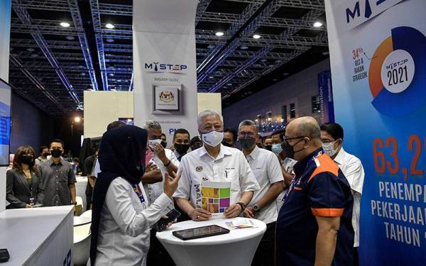 Perdana Menteri Datuk Seri Ismail Sabri Yaakob (tengah) mendengar penerangan daripada petugas ketika melawat ruang pameran sempena Karnival Kerjaya Jamin Kerja Keluarga Malaysia 2022 di Pusat Konvensyen Kuala Lumpur hari ini.