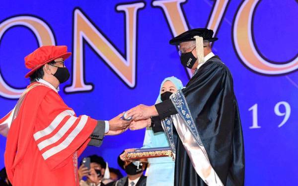 Azman (kanan) menyampaikan penganugerahan Ijazah Doktor Falsafah (Sastera) kepada Budiman pada Majlis Konvokesyen Khas OUM di Dewan Merdeka, Pusat Dagangan Dunia Kuala Lumpur (WTC) pada Sabtu. - Foto Bernama