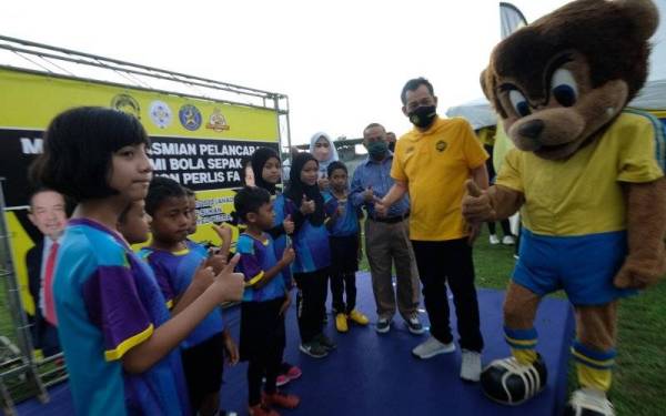 Hamidin beramah-mesra bersama warga akademi selepas menandatangani poster gimik Pelancaran Akademi Bola Sepak Star Lion PFA di Kompleks Sukan Tuanku Syed Putra Kangar pada Ahad. 