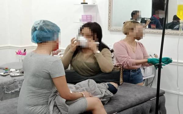 Antara pelanggan yang sedang mendapatkan rawatan ketika serbuan dijalankan Jabatan Imigresen di sebuah premis di Dengkil di sini, pada Isnin.