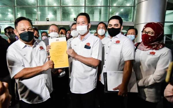 Peter menunjukkan dokumen berhubung pendaftaran parti KDM yang diluluskan RoS sebaik tiba di KKIA, Kota Kinabalu.