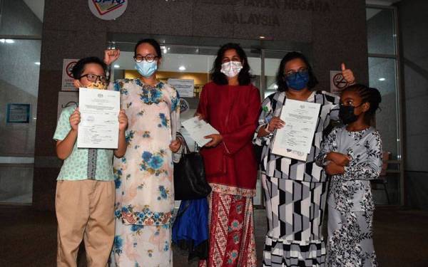 Tiga wakil ibu daripada enam orang keseluruhannya Adlyn Adam Teoh (dua, kiri), Devi (tengah) dan Myra Eliza Mohd Danil (dua, kanan) menunjukkan dokumen kewarganegaraan anak mereka di Jabatan Pendaftaran Negara (JPN) hari ini. - Foto Bernama