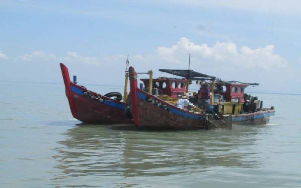 Dua bot pukat kenka yang ditahan Maritim Malaysia selepas didapati melanggar syarat sah lesen di Kuala Kurau. - Foto ihsan Maritim Malaysia