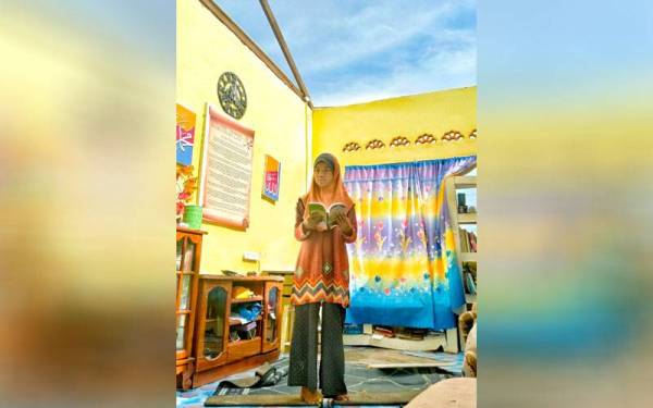 Ahnaf Mah Batttisyia melihat bukunya yang basah terkena hujan selepas bumbung rumah di Kampung Tanah Merah tercabut dalam kejadian ribu pada Isnin lalu.