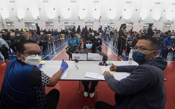 Mangsa banjir P Janaki (tengah) menunjukkan sampul yang diterimanya ketika hadir mendapatkan bantuan bencana banjir daripada Kerajaan Persekutuan dan Kerajaan Negeri di Dewan Majlis Bandaraya Shah Alam (MBSA) Kemuning Utama Seksyen 33, hari ini.