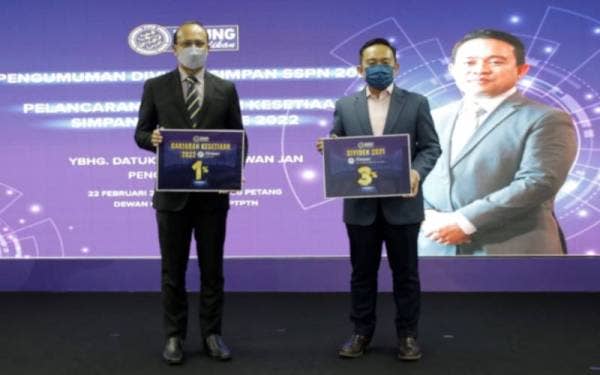 Wan Saiful (kanan) dan Ahmad Dasuki (kiri) memegang replika dividen tiga peratus dan Ganjaran Kesetiaan satu peratus.