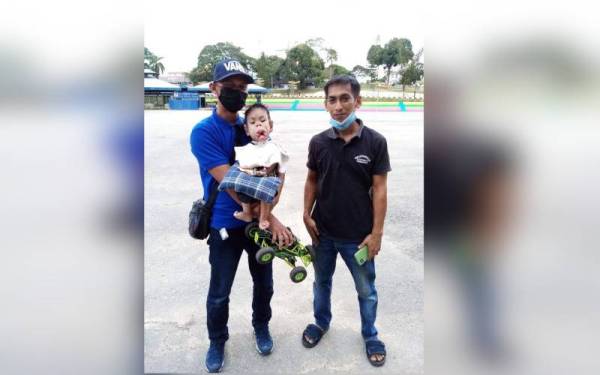 Nordin (kiri) sanggup memandu sejauh 60km dari Felda Ulu Jempol demi menunaikan impian Mohd Aqil untuk melihat pertunjukan kereta kawalan jauh di Dataran Temerloh.