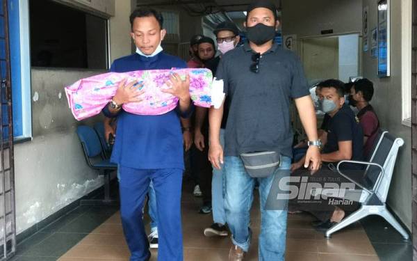 Yuseri memegang jenazah anaknya.