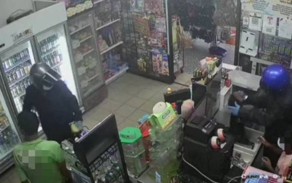 Tangkap layar video tular memaparkan dua lelaki bertopi keledar menyamun sebuah kedai runcit di Menglembu.