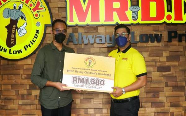 Pegawai Perhubungan Awam dan Kutipan Derma BRDB Rotary Children Residence, Nazmi Nasiron, (kiri) menerima baucar tunai daripada Penolong Pengurus Penjenamaan MR D.I.Y. Group (M) Berhad, Muhammad Nuramin (kanan).