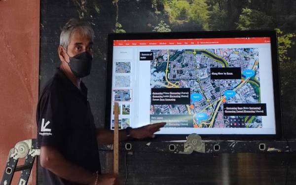 Andrew menunjukkan peta kawasan sekitar Taman Sri Muda dan lokasi sekitar bagi menjelaskan punca banjir di kawasan tersebut.