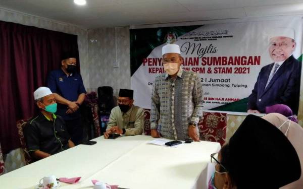 Idris (berdiri) menyampaikan ucapan ketika Majlis Penyampaian Sumbangan Kepada Calon SPM dan STAM 2021 di Dewan Restoran Nasi Ayam Hainan Simpang, di sini pada Jumaat.