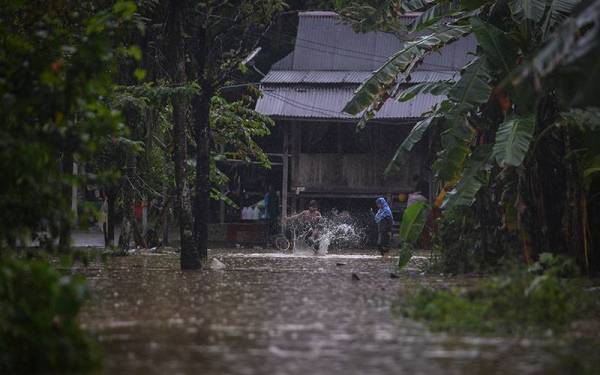 Gelagat kanak-kanak bermain takungan air di hadapan rumah mereka ekoran hujan lebat semasa tinjauan di Kampung Kepah hari ini. 