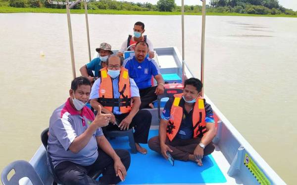 Omar (belakang) menyediakan perkhidmatan sewa bot bagi memberi peluang pengunjung berekreasi dan menikmati pemandangan indah perairan Sungai Muda.