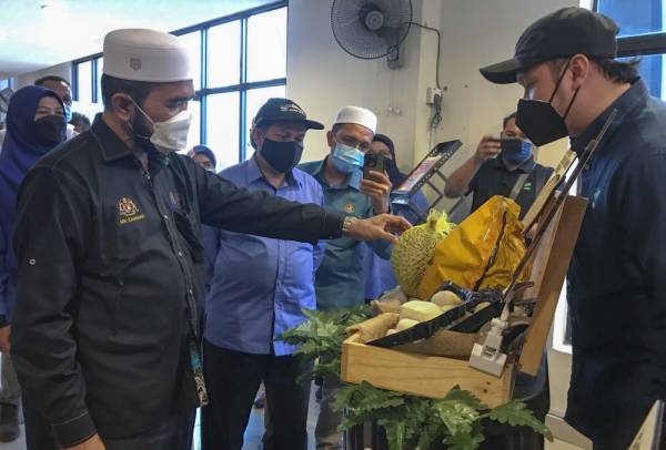 Nik Muhammad Zawawi (kiri) melawat pameran selepas merasmikan Kursus Galakan Pelaburan dan Pembangunan Tanaman Durian di Dewan Serai Wangi Kompleks RTC, Tunjong hari ini. -Foto Bernama