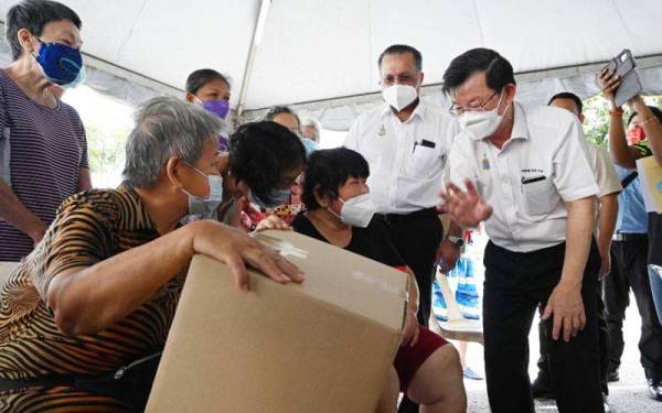 Kon Yeow (kanan) dan Jagdeep (dua dari kanan) berbual bertemu penduduk yang menerima sumbangan bakul makanan pada Ahad.