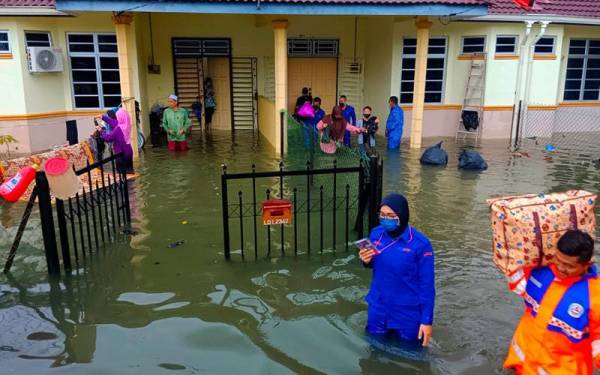 Anggota APM Pasir Mas membantu keluarga Nurhaya untuk ke PPS berhampiran selepas kediamannya di Taman Mesa, Pasir Mas dinaiki air.