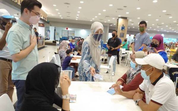 Nurul Izzah (tengah) beramah mesra dengan orang ramai semasa melakukan 'walk about' di sebuah pasar raya besar di Kulai, pada Ahad.