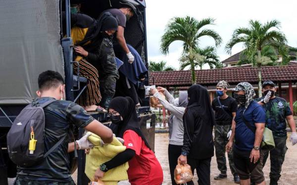 Seramai 82 calon Sijil Pelajaran Malaysia (SPM) dari Sekolah Menengah Kebangsaan Ayer Puteh menaiki trak polis untuk dipindahkan ke asrama Sekolah Menengah Kebangsaan Cheneh Baru berikutan sekolah itu dinaiki air di sini, pada Isnin. - Foto Bernama 