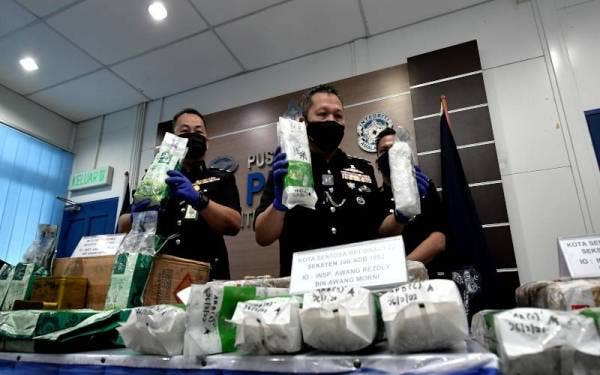 Mancha (dua dari kiri) menunjukkan dadah diedar menggunakan perkhidmatan kurier yang dirampas polis pada sidang media di IPK Sarawak, Kuching pada Selasa. - Foto Bernama