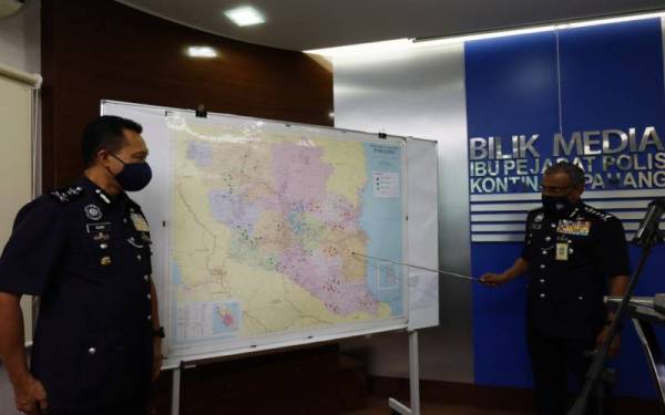 Ramli (kanan) menunjukkan lokasi operasi Op Tapis Khas kali yang diadakan membabitkan 28 kawasan di seluruh Pahang.