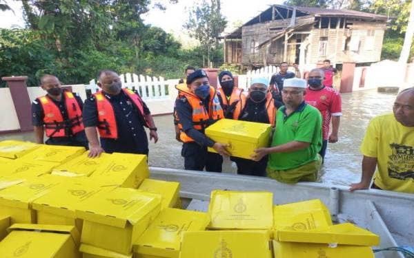 Muhammad Zaki (tiga dari kiri) menyampaikan sumbangan yang dikuniakan oleh Raja Perempuan Kelantan, Tengku Anis.