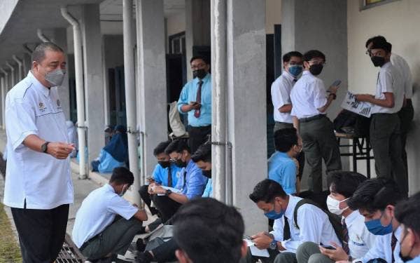 Tengku Shahrir (kiri) memberi kata-kata semangat kepada pelajarnya yang akan menduduki peperiksaan Sijil Pelajaran Malaysia (SPM) 2021, pada Rabu. - Foto Bernama