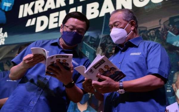 Muhyiddin (kanan) bersama Presiden Gerakan Datuk Dr Dominic Lau Hoe Chai melihat buku Ikrar Perikatan Nasional 'Demi Bangsa Johor' pada majlis pelancaran buku itu di sebuah hotel hari ini. Foto Bernama