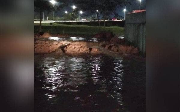 Limpahan air berlaku akibat ban pecah berhampiran pintu kunci air di Taman Sri Muda, Seksyen 25, pada Rabu.