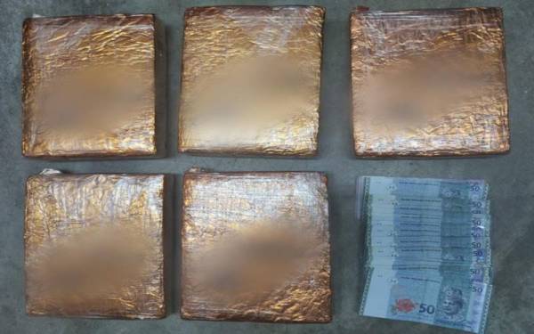 Ketulan ganja mampat dan sejumlah wang yang dirampas daripada suspek.