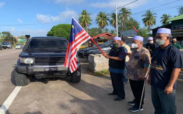 Wan Roslan (tiga, kanan) melepaskan konvoi Misi Bantuan Banjir DUN Pengkalan Kubor di Tumpat, pada Khamis.