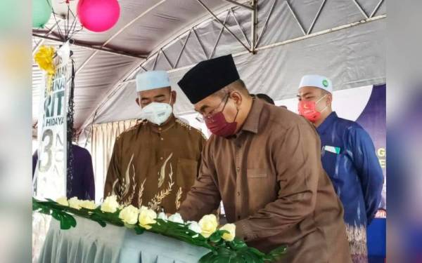 Muhammad Sanusi (kanan) menandatangani plak perasmian Sekolah Rendah Integrasi Teras Islam (SRITI) Nurul Hidayah di Pekan Naka di sini pada Khamis.