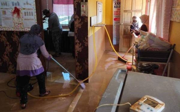 Kakitangan KKM sedang dalam operasi membersihkan kawasan yang dinaiki air.