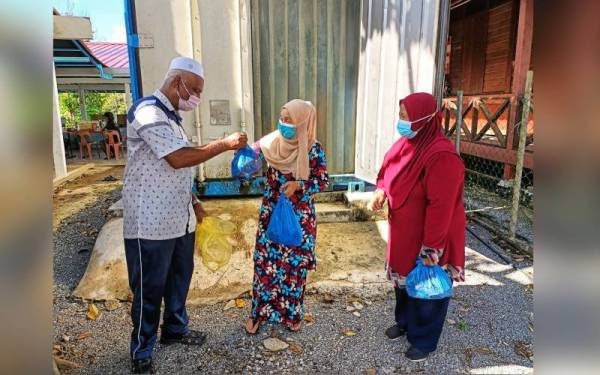 Zainol Abidin (kiri) menjual daging tempatan sejuk beku di ladang ternakannya.
