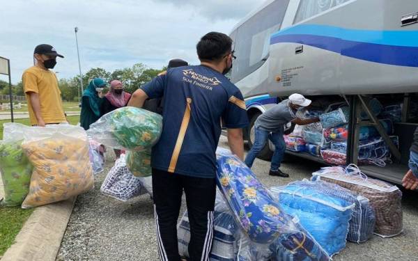 Sukarelawan USIM menyusun tilam yang akan disumbangkan kepada mangsa banjir di Terengganu.