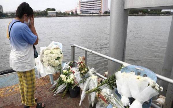 Seorang wanita memberikan penghormatan terakhir kepada mendiang Tangmo Nida di lokasi kemalangan di di jeti Pibul 1 di Nonthaburi, Bangkok. - Agesni