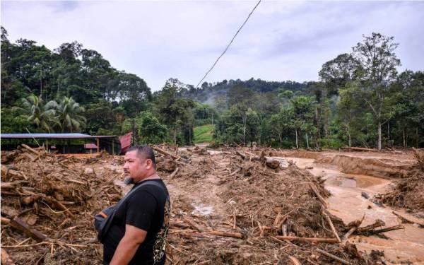 Keadaan di hadapan sebuah rumah yang dipenuhi timbunan kayu dan lumpur susulan banjir besar melanda ketika tinjauan di Kampung Belukar Bukit, pada Jumaat. - Foto Bernama 