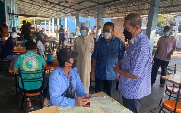 Azizul (dua,dari kanan) ketika beramah mesra bersama penduduk Tiram dalam lawatan kempennya di sini pada Jumaat.