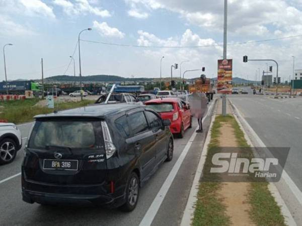 Peniaga di persimpangan lampu isyarat sedang menjalankan aktiviti mereka di beberapa kawasan di Puncak Alam.