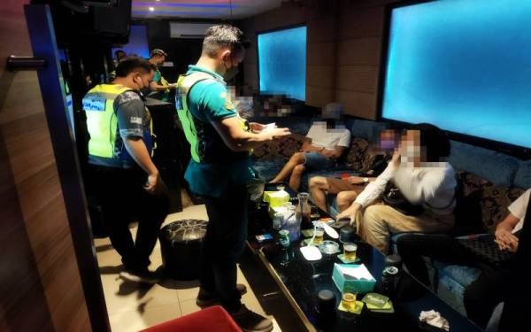 Antara individu yang dikompaun ketika serbuan di sebuah pusat karaoke di Petaling Jaya pada Ahad. 