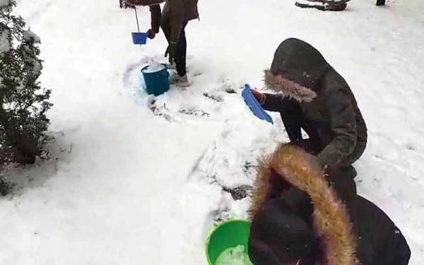 Pelajar-pelajar India mengumpulkan salji untuk dicairkan bagi dijadikan air minuman di Sumy, Ukraine baru-baru ini. - Foto The Telegraph