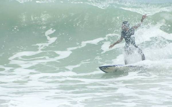 Aksi Mat Jeng ketika meluncur ombak di perairan pantai Cherating.