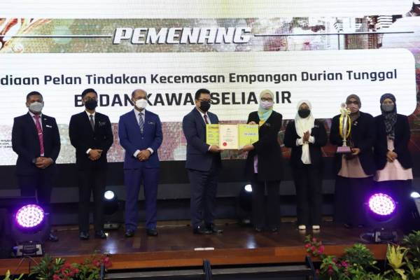 Sulaiman (empat,kiri) menyampaikan anugerah kepada BKSA Melaka yang diwakili Faizah (lima,kiri) ketika Majlis Anugerah Projek/Program Terbaik dan Anugerah Kajian Penilaian Outcome peringkat negeri 2021 di sebuah hotel di Jalan Persisiran Bunga Raya di sini, pada Isnin.