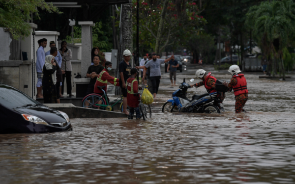 Anggota Bomba dan Penyelamat dilihat membantu mengalihkan kenderaan orang awam yang ditenggelami air di sekitar kawasan perumahan di Lorong Gurney pada Isnin. - Foto Bernama